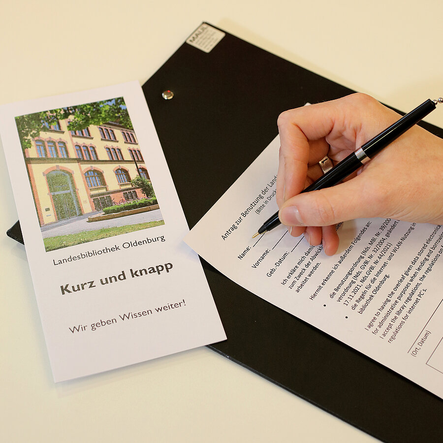 Eine Hand füllt den Anmeldebogen aus. Daneben eine Informationsbroschüre mit dem Titel "Kurz und knapp".