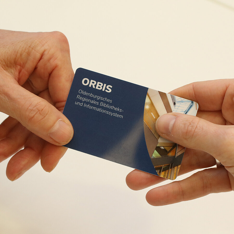 Zwei Hände halten einen ORBIS-Bibliotheksausweis.
