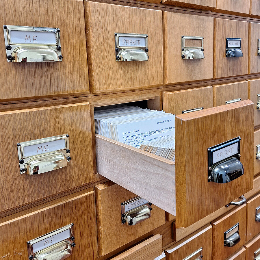 Zettelkasten mit geöffneter Schublade. Darin Karteikarten.