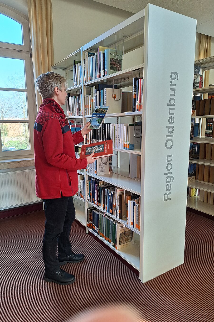 Eine Frau steht vor einem Regal mit der Aufschrift "Region Oldenburg".