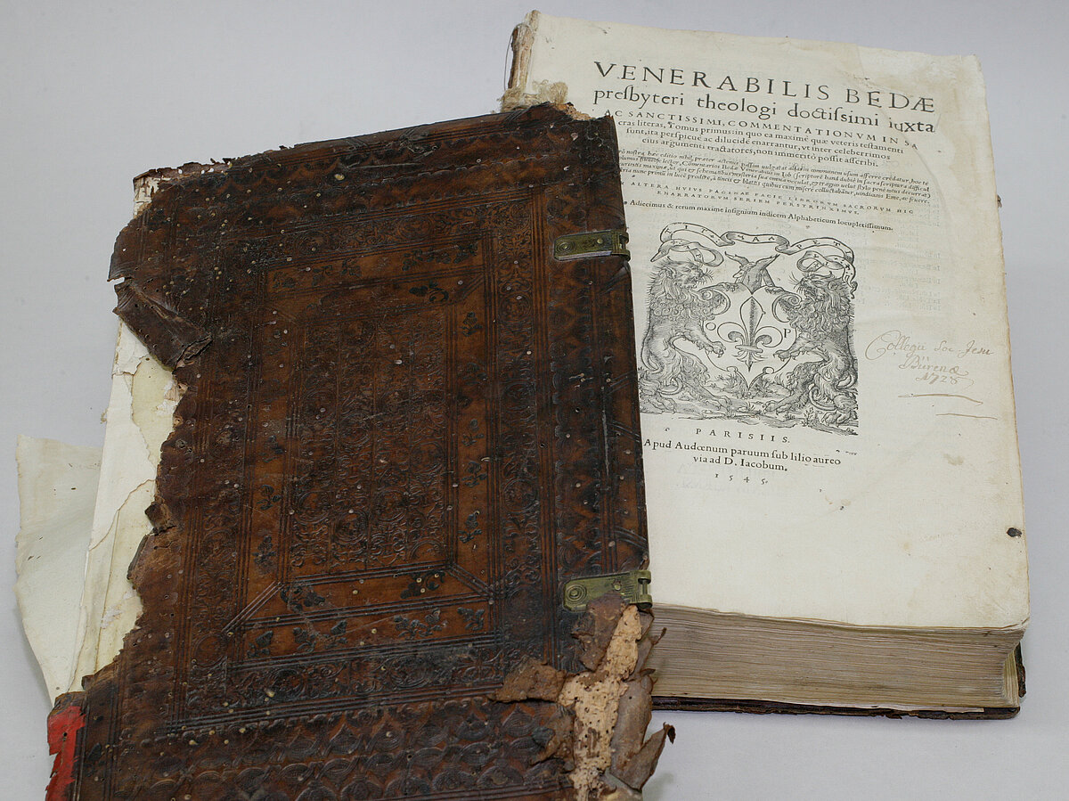 Historisches Buch, bei dem der Deckel vollständig vom Buchblock gelöst ist.