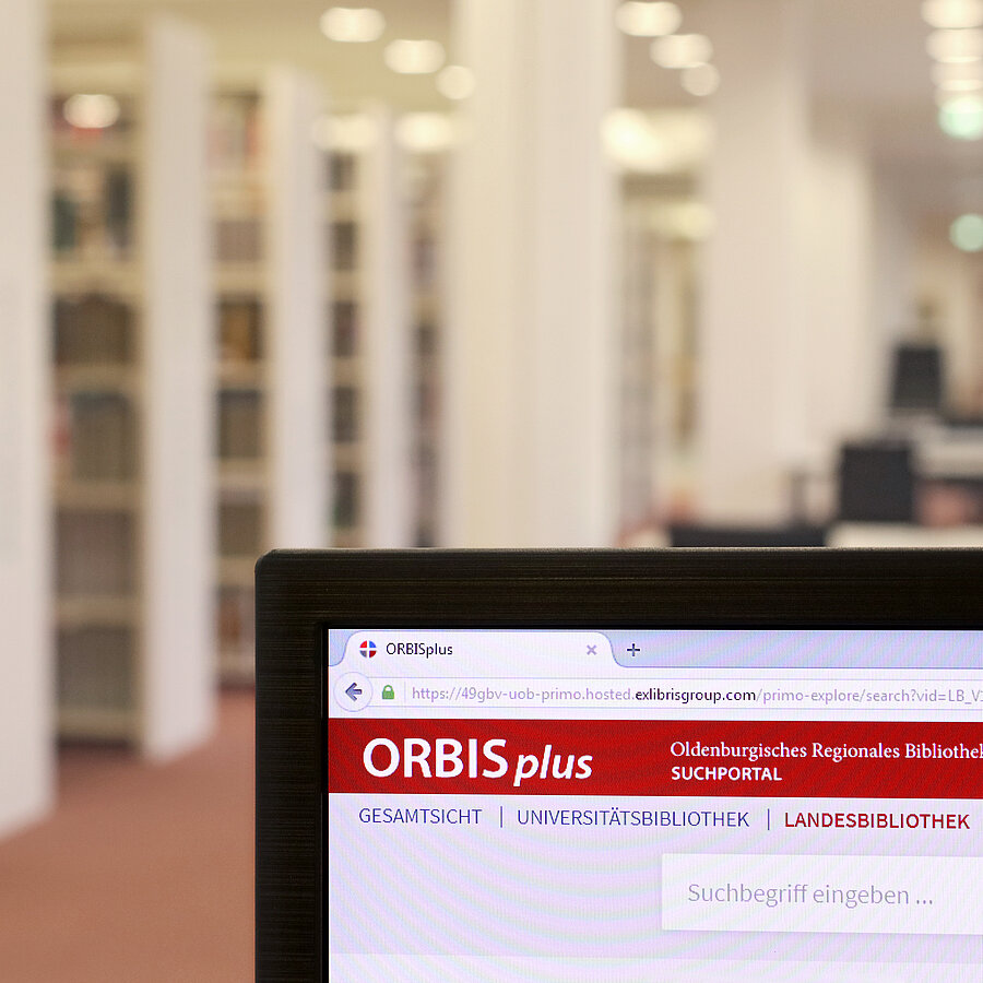 ORBISplus Katalog auf einem PC-Bildschirm. Im Hintergrund Regalreihen.