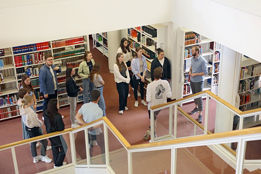 Bibliotheksmitarbeiter Leon Werth zeigt den Studierenden das Lern- und Informationszentrum.