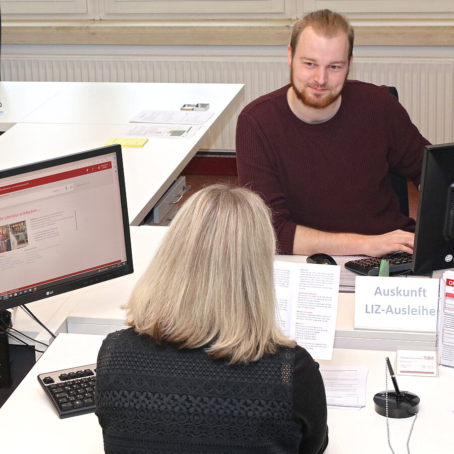 Auskunftsgespräch an der Auskunftstheke auf Ebene 1 des Lern- und Informationszentrums. 