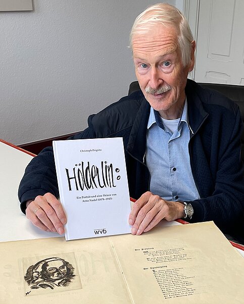 Christoph Prignitz im Dezember 2022 mit der Hölderlin-Radierung von Arno Nadel und seiner Publikation Hölderlin: Ein Porträt und eine Skizze von Arno Nadel (1878–1943). Foto: Leon Werth.